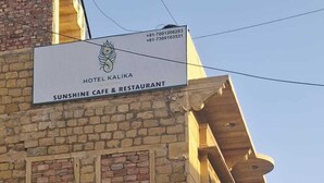 Een gebouw met een bord voor Hotel Kaliya Sunshine Cafe & Restaurant.
