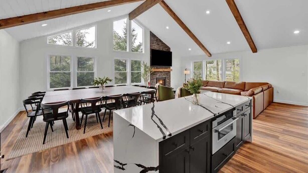 A spacious kitchen with a large island, wooden beams, and a fireplace. - Private Pool Chalet | HotTub | Firepit | Game Room (Blakeslee)