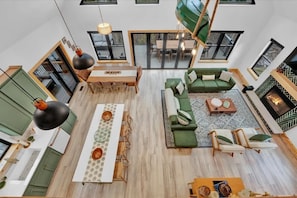 A spacious living area with a dining table, sofa set, and a fireplace.