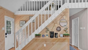 A staircase with a wooden finish and white railings, leading to an upper floor.