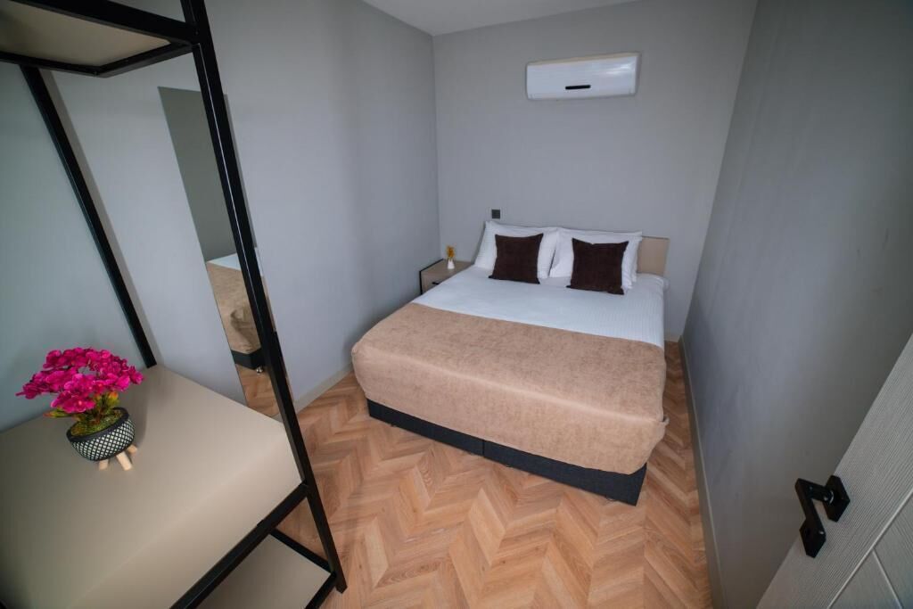 Una camera da letto con un letto, un comodino e una pianta in vaso.