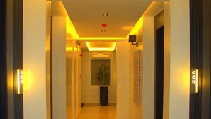 A hotel corridor with a polished floor, illuminated by recessed lighting, and numbered doors. - The Cordis Hotel Ikeja (Lagos)