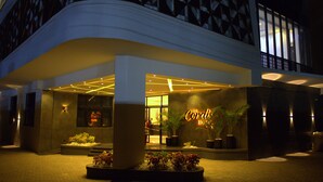 A hotel entrance with a modern design, featuring a prominent sign, a well-lit entrance, and landscaped areas with plants. - The Cordis Hotel Ikeja (Lagos)