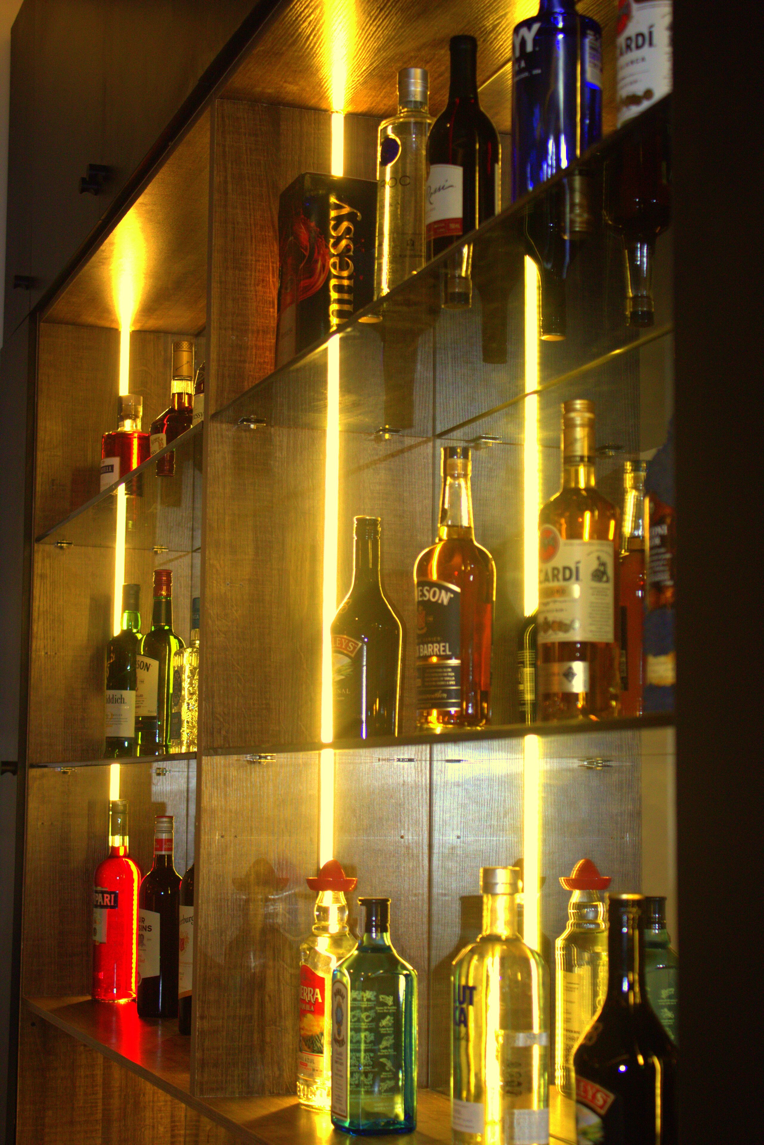 A bar with shelves of various liquor bottles.