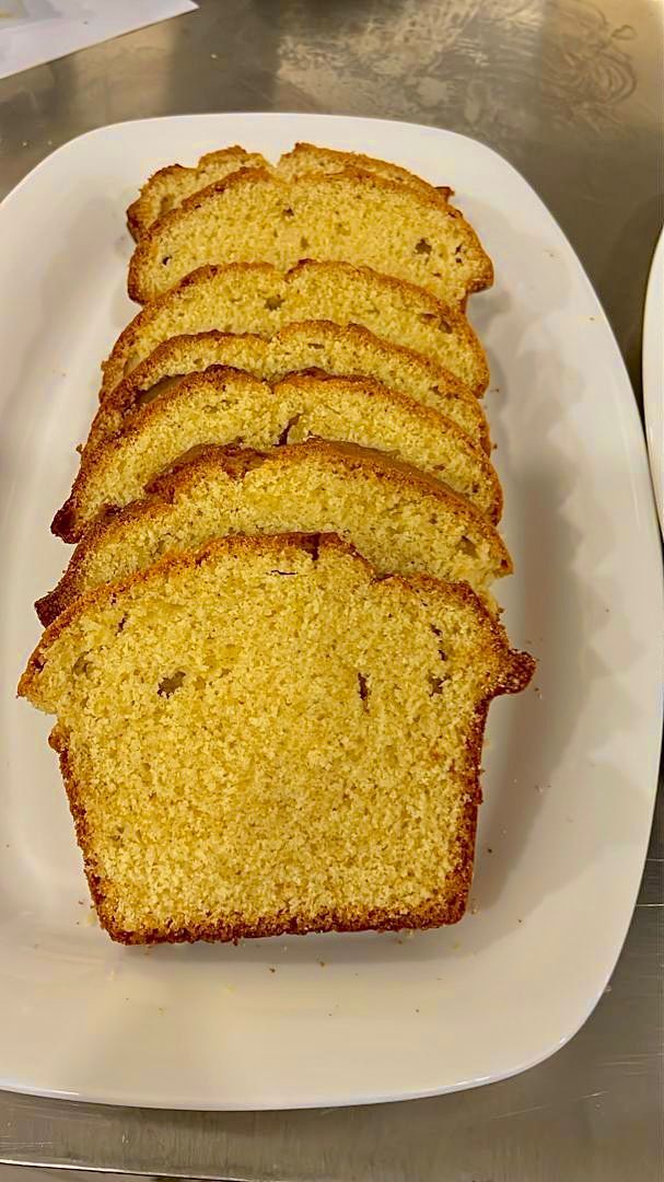 A white plate with several slices of yellow cake arranged in a row.