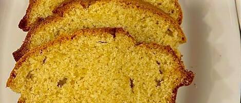 A white plate with several slices of yellow cake arranged in a row.