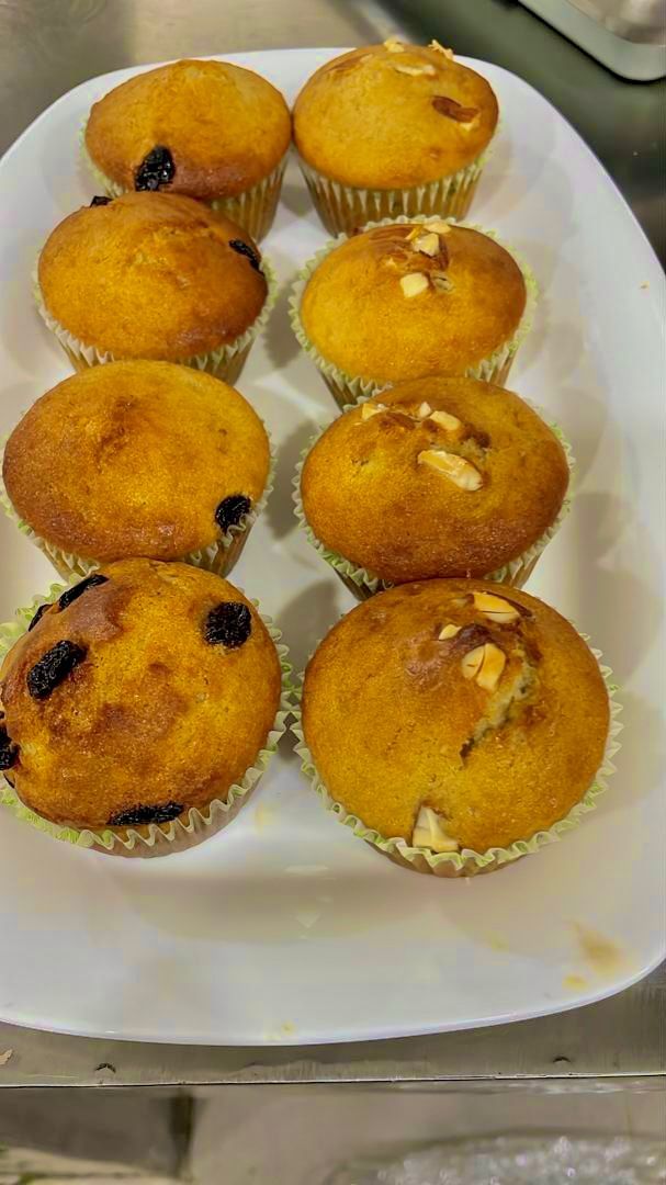 A tray of muffins with raisins and nuts, placed on a white plate.