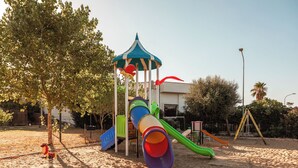 A playground with a slide, climbing structures, and a covered play area. - Residence camping Atlantide (Capitolo)