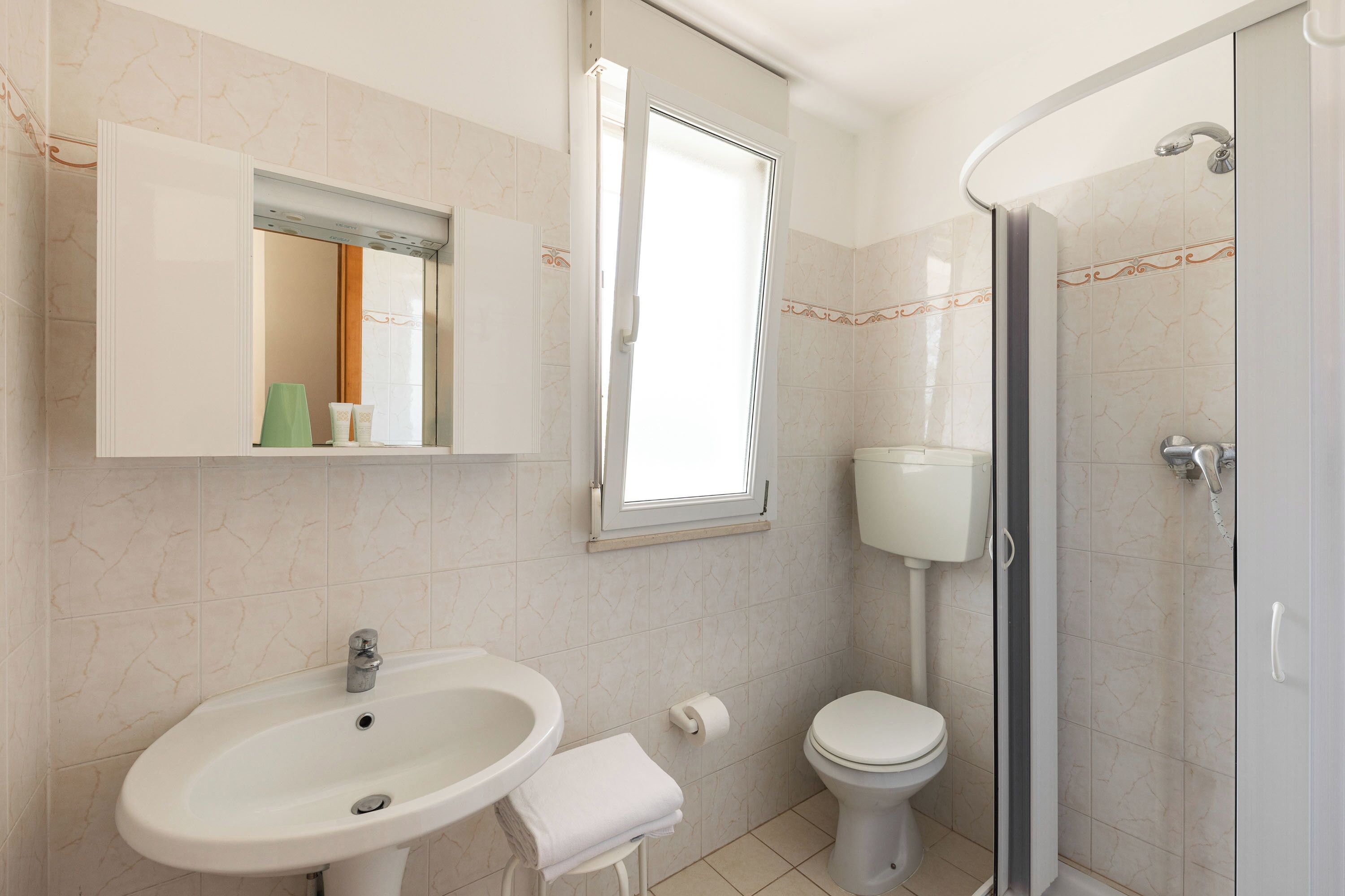 A bathroom with a sink, toilet, and shower.