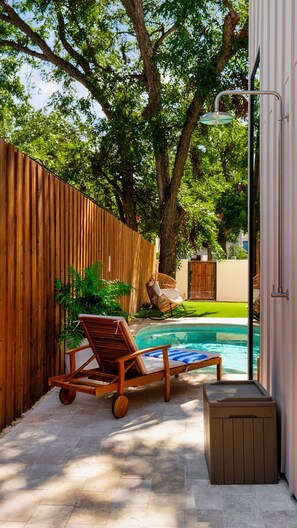 A wooden fence, a lounge chair, a small pool, and a trash bin. - Eastside Lux Group Retreat W/ Pool near Downtown (Austin)