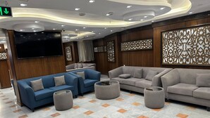 Ein modernes Wohnzimmer mit Sofas, Hocker und einem Flachbildfernseher.