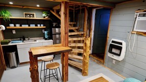 Une cuisine rustique, avec des meubles en bois, un four encastré et un petit réfrigérateur.