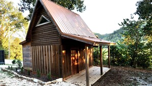 Une cabane en bois avec un toit en pente et une véranda.