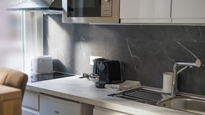 Eine moderne Küche mit integriertem Mikrowellenherd, einer Kaffeemaschine, einem Toaster und einem Spülbecken.