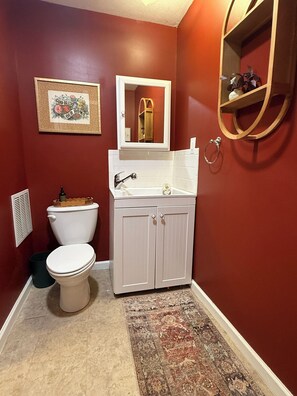 Une salle de bain avec des toilettes, un lavabo et un miroir.