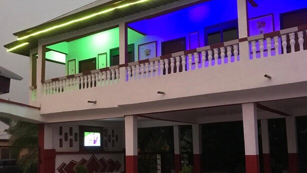Een gebouw met twee verdiepingen, een balkon, betegelde vloeren en bloempotten.