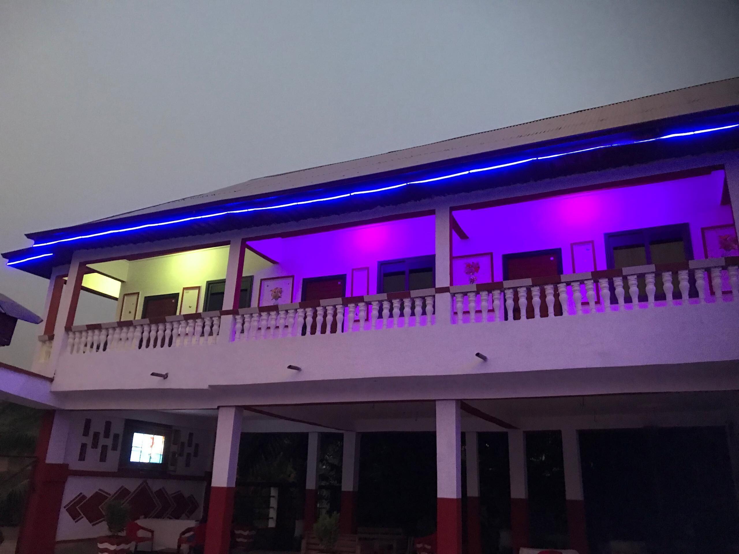 A two-story building with a balcony, white walls, and a red and white color scheme.