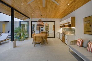 Un intérieur moderne comprenant un coin repas, une cuisine et un espace salon.