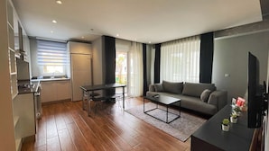 A compact living space with a kitchenette, dining area, and seating area. - Sun Suite (Antalya)