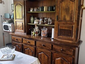 Un meuble de cuisine en bois, doté de plusieurs étagères, de tiroirs et d’un compartiment pour micro-ondes.
