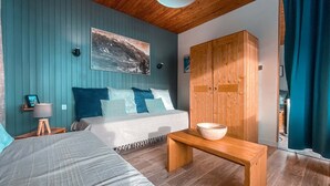 Un dormitorio con cama, mesita de noche, armario de madera y un cuadro en la pared.