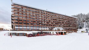 A multi-story hotel with a modern architectural design, featuring balconies and large windows. - Renovated Studio Cabin - On the Slopes at Plagne Centre (La Plagne-Tarentaise)