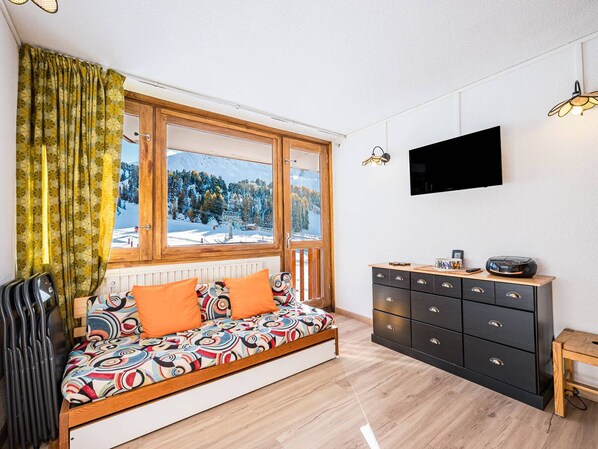 Ein modernes Zimmer mit einer Holzsofa, einem Fernseher und einer Kommode.