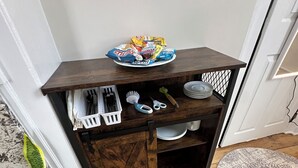 A corner storage unit with a plate of snacks, a brush, and a pair of scissors. - Liz Room in downtown Exeter next to PEA (Exeter)
