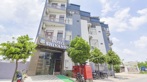A multi-story hotel with a modern design, featuring balconies, air conditioning units, and a green entrance ramp. - Hotel Shivansh (Jaipur)