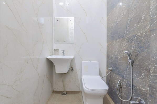 Baño con inodoro, lavabo y ducha.