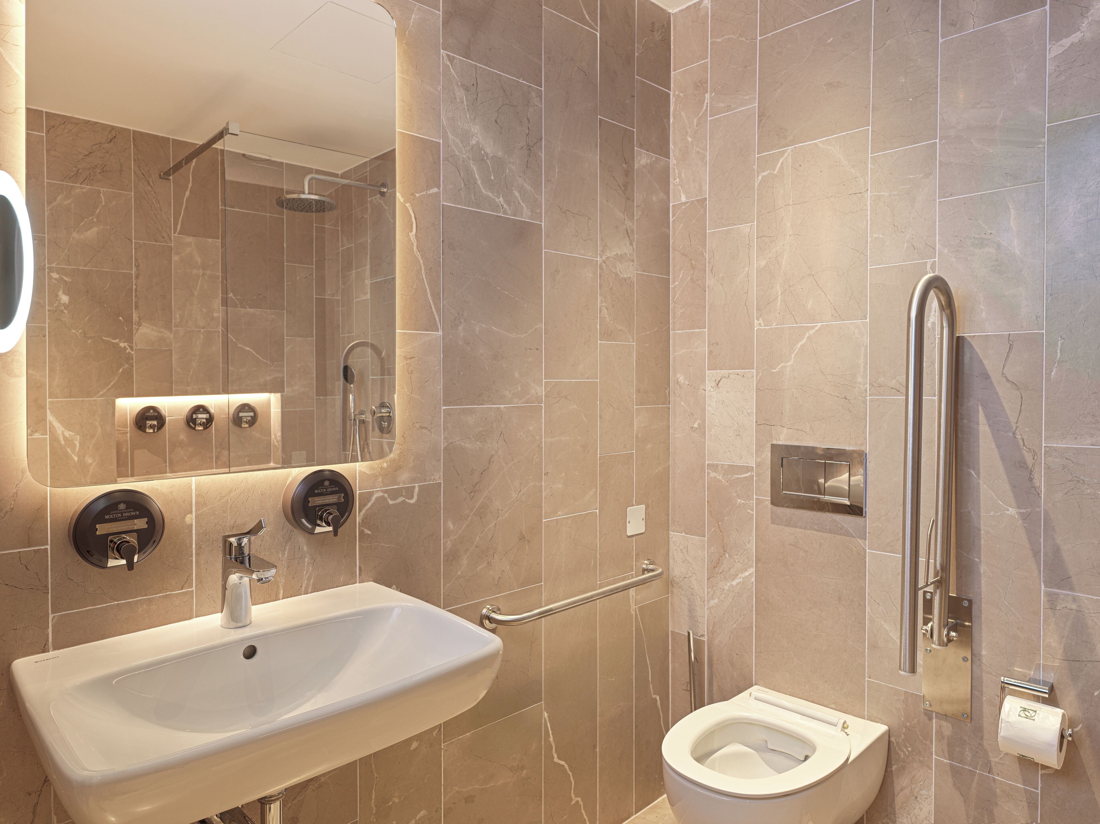 A modern bathroom with a sink, toilet, and shower.