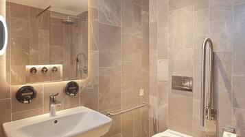 A modern bathroom with a sink, toilet, and shower.