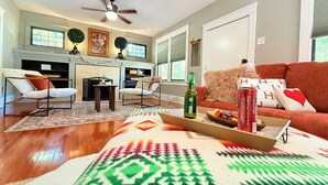 Ein Wohnzimmer mit Kamin, einer Couch, einem Couchtisch mit Snacks und einem Deckenventilator.