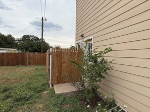 A residential property with a wooden fence, a front door, and a small garden area. - Eleven South: One - Modern Studio Apartment (Abilene)