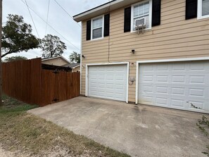 A two-story house with a garage and a wooden fence.