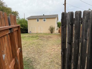 A two-story house with a front yard and a wooden fence. - Eleven South: One - Modern Studio Apartment (Abilene)