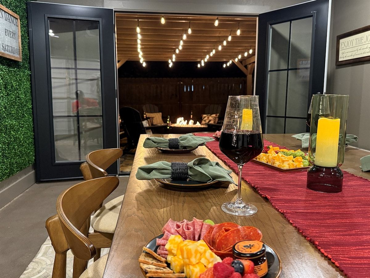 Un coin repas avec une table en bois dressée pour deux personnes, où l’on trouve une variété de plats et de boissons.