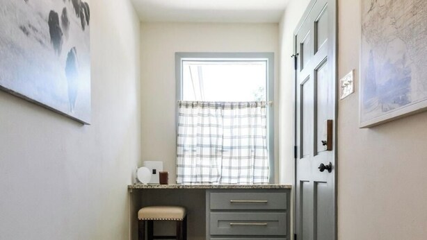 A narrow hallway with a bench, a desk, and a wardrobe. - Howdy Y’all Ranch | Luxe Western Retreat (Abilene)