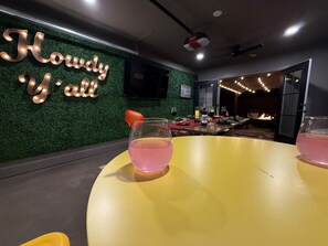 A room with a green wall, a yellow table, and a pink drink. - Howdy Y’all Ranch | Luxe Western Retreat (Abilene)