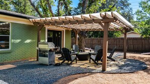 A patio with a grill, outdoor seating, and a pergola. - Howdy Y’all Ranch | Luxe Western Retreat (Abilene)