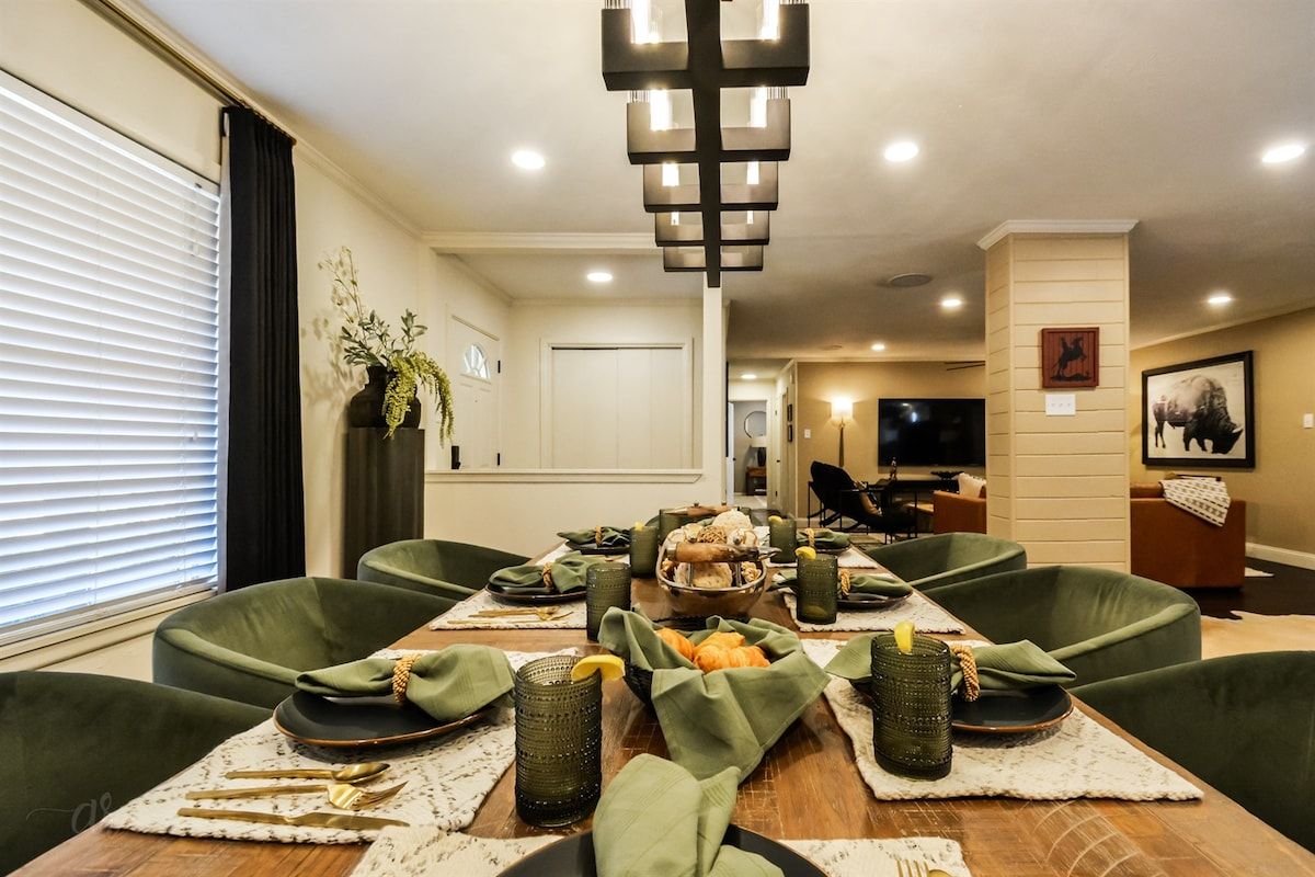 Een eethoek met een houten tafel voor vier personen, omringd door groene fauteuils.