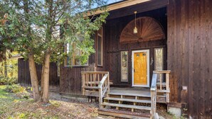 A rustic wooden building with a wooden porch and a large door.