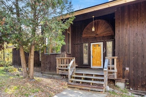 A rustic wooden building with a wooden porch and a large door.