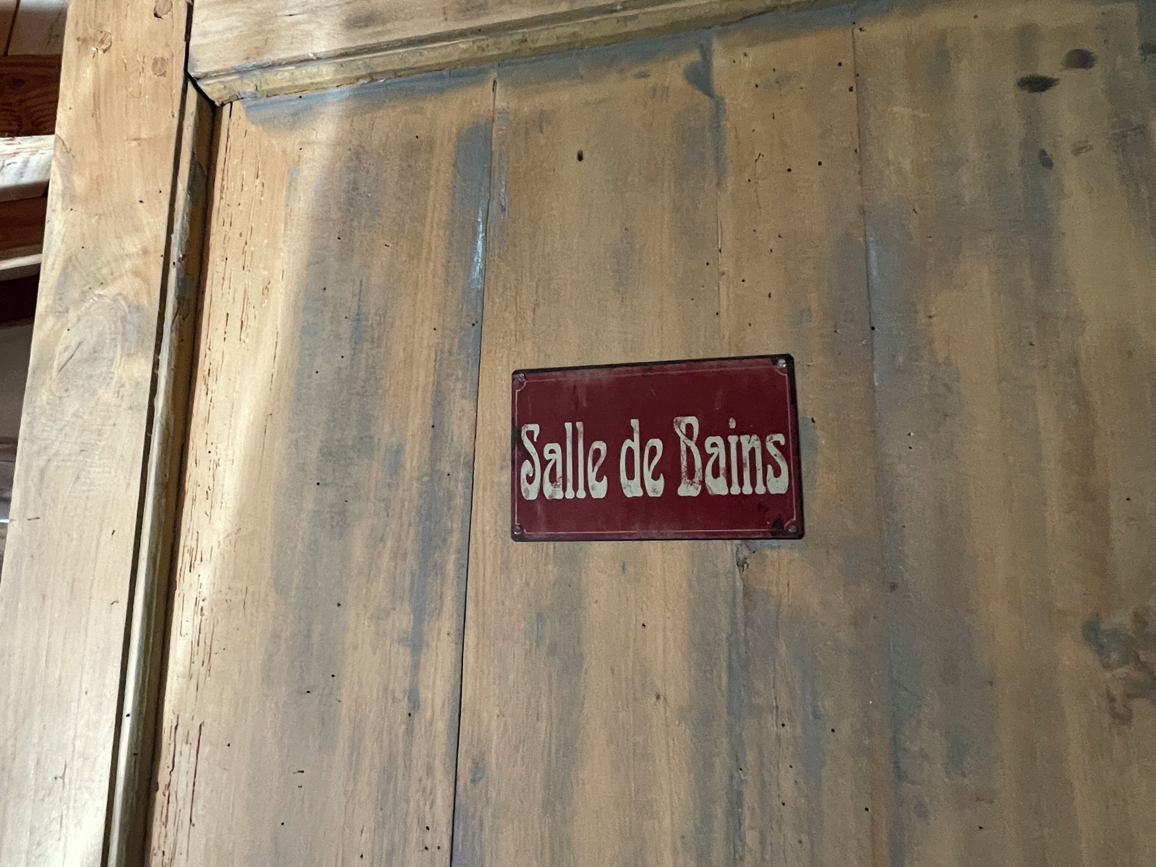 A wooden wall with a sign that reads "Salle de Bain".