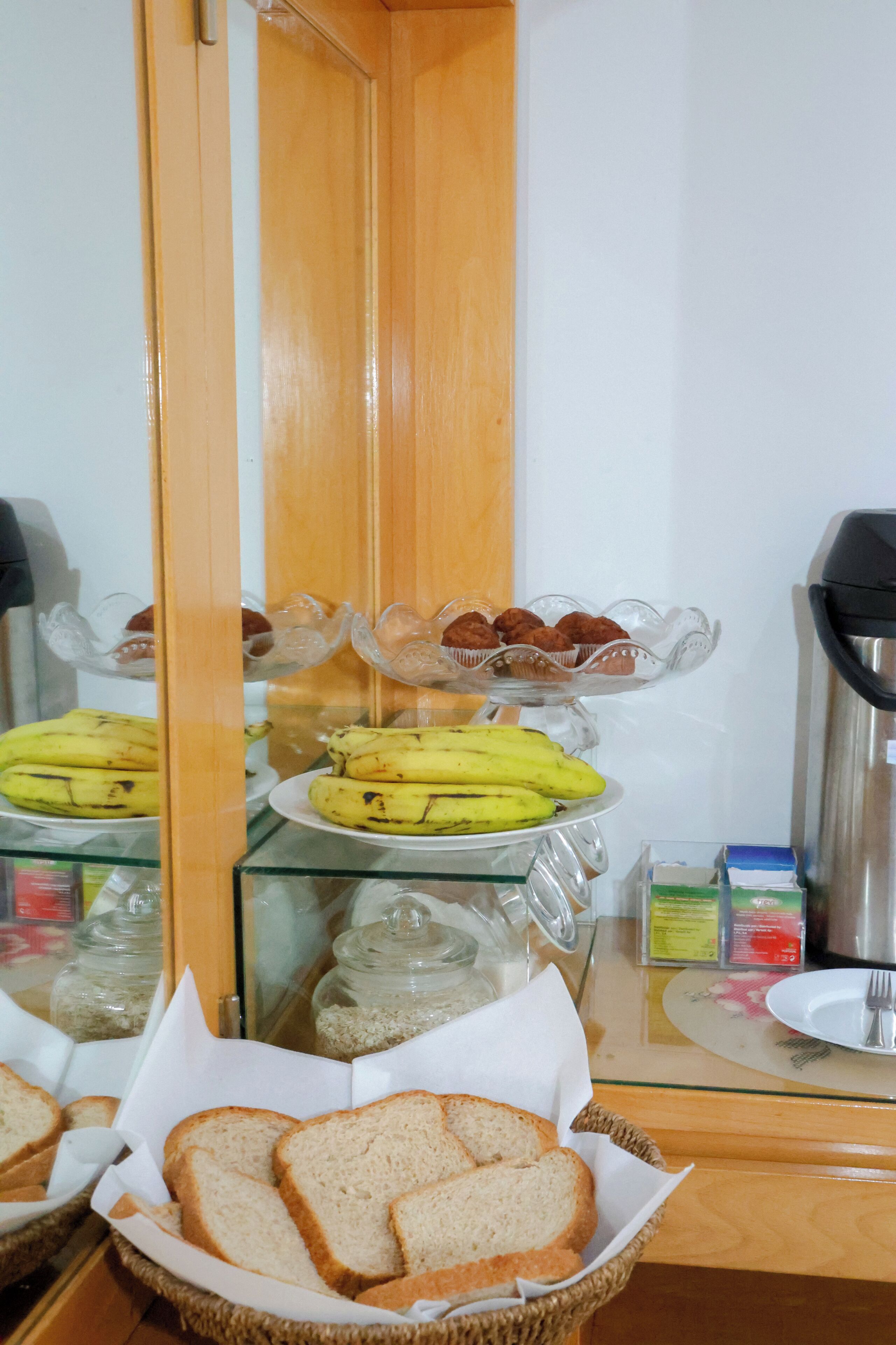 Un ricco buffet della colazione con pane, muffin e banane.