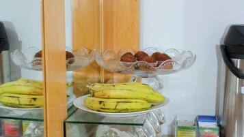 Un ricco buffet della colazione con pane, muffin e banane.