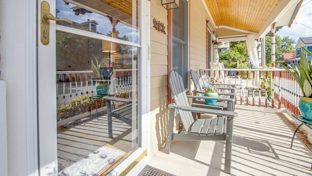 A wooden porch with two lounge chairs and a potted plant. - **New Listing for 2026** Classic Downtown Historic Lewes Home two blocks to Second Street and only 4minutes to the Beach (Lewes)