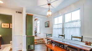 A dining area with a wooden table and benches, a ceiling fan, and large windows with sheer curtains. - **New Listing for 2026** Classic Downtown Historic Lewes Home two blocks to Second Street and only 4minutes to the Beach (Lewes)