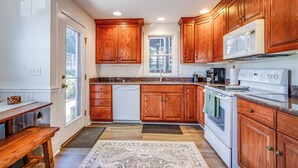 A kitchen with wooden cabinets, a white dishwasher, a stove, and a microwave. - **New Listing for 2026** Classic Downtown Historic Lewes Home two blocks to Second Street and only 4minutes to the Beach (Lewes)