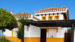 A two-story building with a tiled roof, a covered entrance, and a number '59' on the wall.